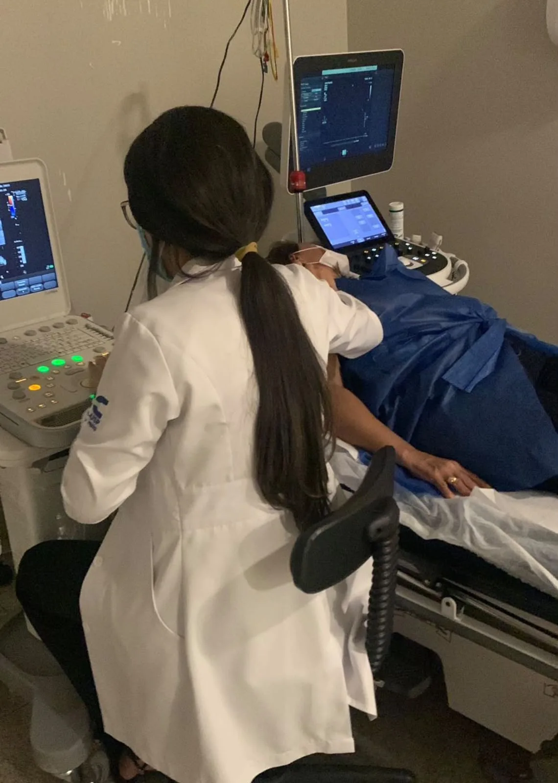 Dra. Roberta realizando ecocardiograma em paciente deitado